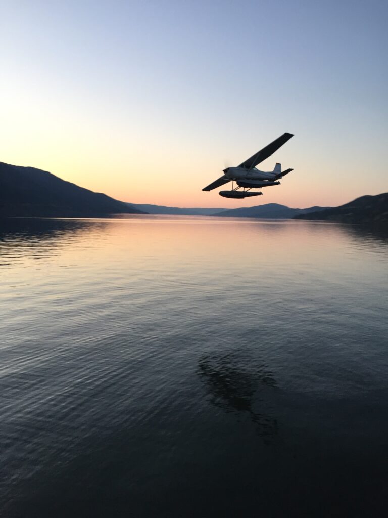 seaplane flying low over lake at dusk